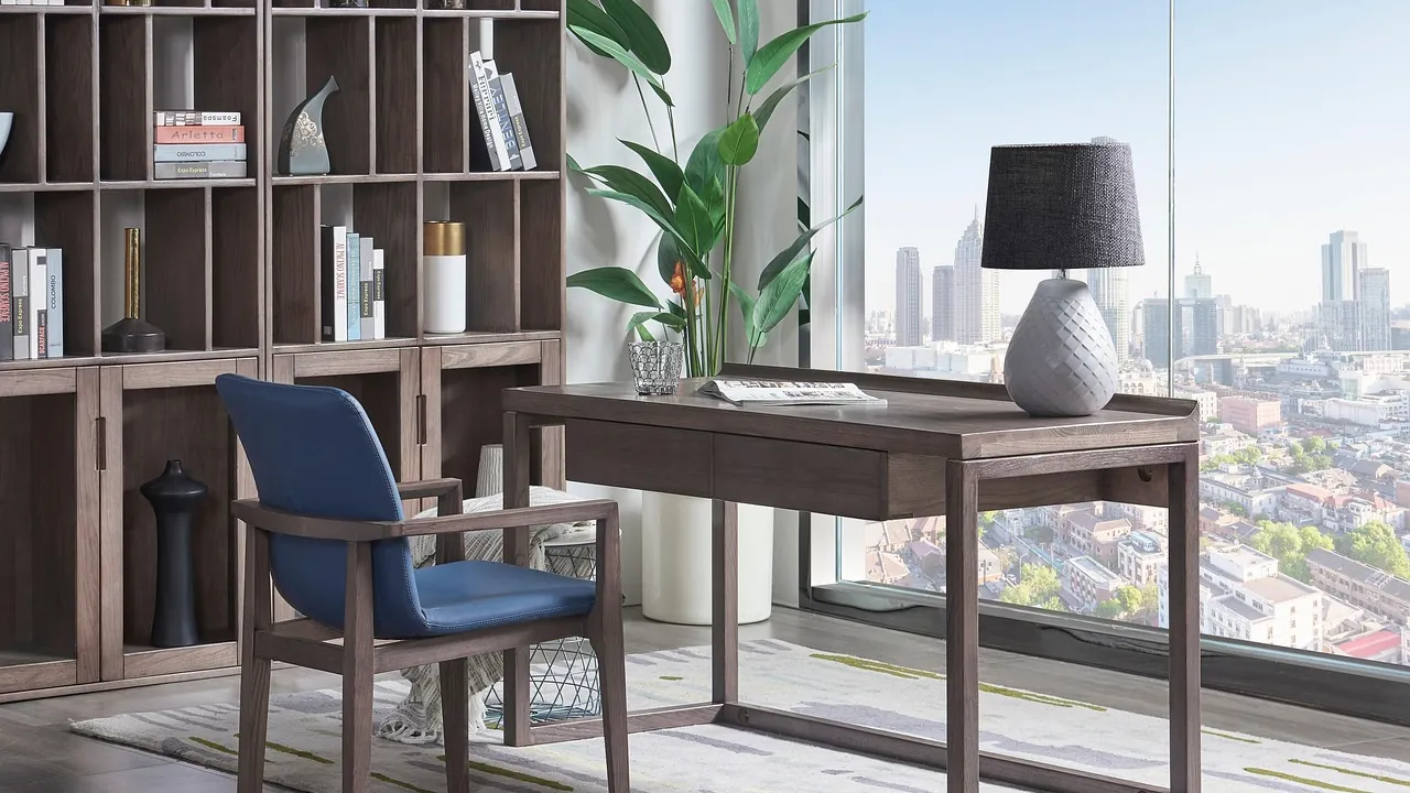 Un bureau et une chaise seule devant une baie vitrée ouverte sur la ville