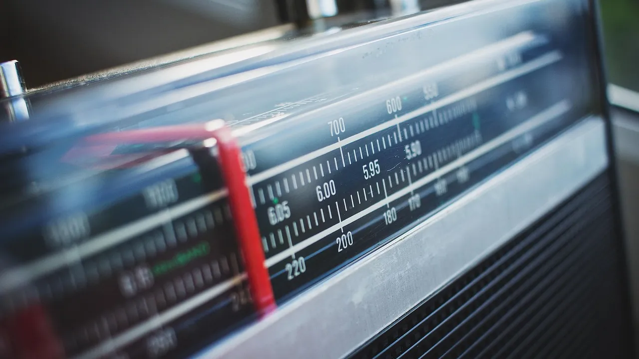 L’aiguille rouge d’un poste de radio ancien, arrêtée sur une fréquence